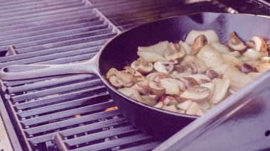 Adım adım. Izgara mantar ve soğan dökme demir tavada açık gaz ızgara.