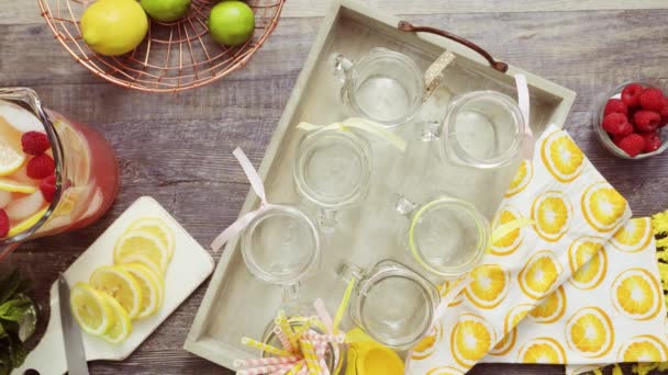 循序渐进 在喝梅森罐子里浇上新鲜柠檬和覆盆子的覆盆子柠檬水 — 图库视频影像