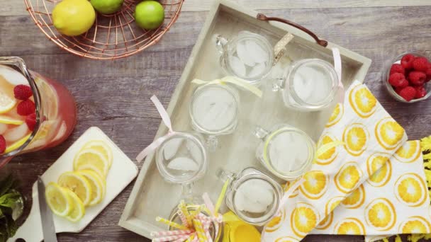 단계적으로 신선한 레몬과 메이슨 단지에 딸기와 라즈베리 쏟아져 레모네이드 — 비디오