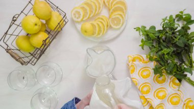 Adım adım. Cam sürahi içinde geleneksel taze limonata hazırlanıyor.