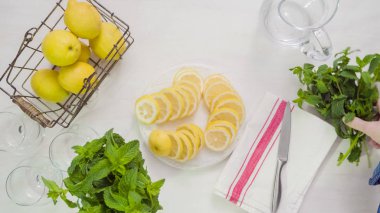 Adım adım. Beyaz ahşap kesme tahtası üzerinde taze organik limon Dilimleme.