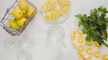 Adım adım. Cam sürahi içinde geleneksel taze limonata hazırlanıyor.