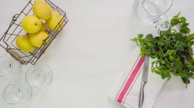 Adım adım. Beyaz ahşap kesme tahtası üzerinde taze organik limon Dilimleme.