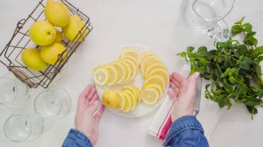 Adım adım. Beyaz ahşap kesme tahtası üzerinde taze organik limon Dilimleme.