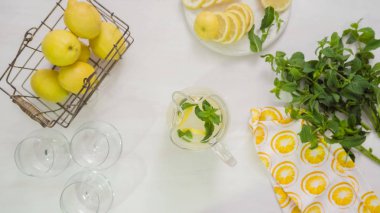 Adım adım. Cam sürahi içinde geleneksel taze limonata hazırlanıyor.