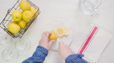 Adım adım. Beyaz ahşap kesme tahtası üzerinde taze organik limon Dilimleme.