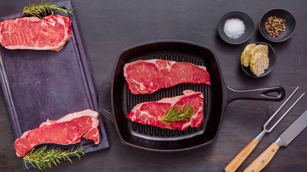 Dökme demir tavada ham New York şerit biftek.