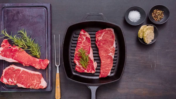 Dökme demir tavada ham New York şerit biftek.