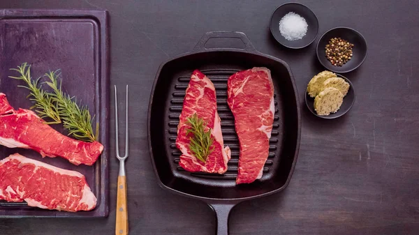 Dökme demir tavada ham New York şerit biftek.