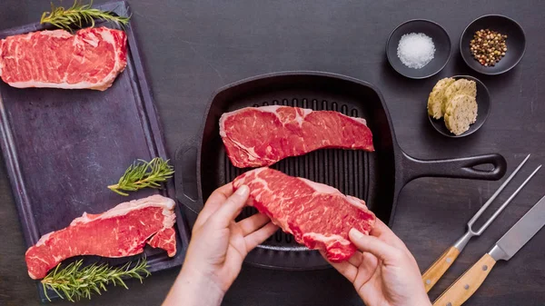 Dökme demir tavada ham New York şerit biftek.