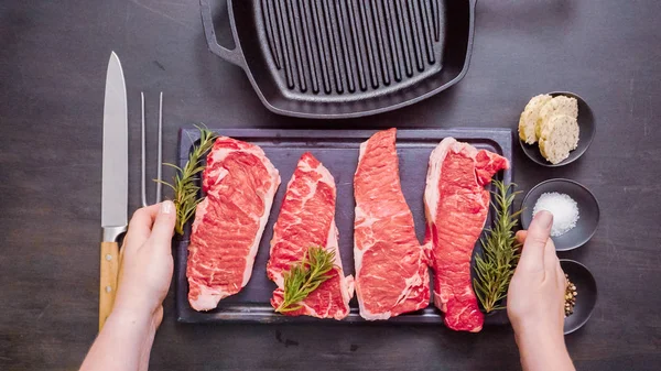 Dökme demir tavada ham New York şerit biftek.