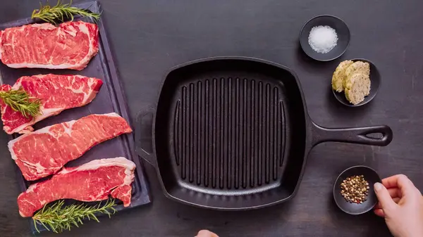 Dökme demir tavada ham New York şerit biftek.