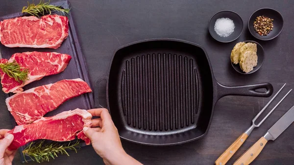 Dökme demir tavada ham New York şerit biftek.