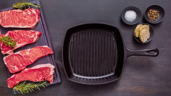 Dökme demir tavada ham New York şerit biftek.