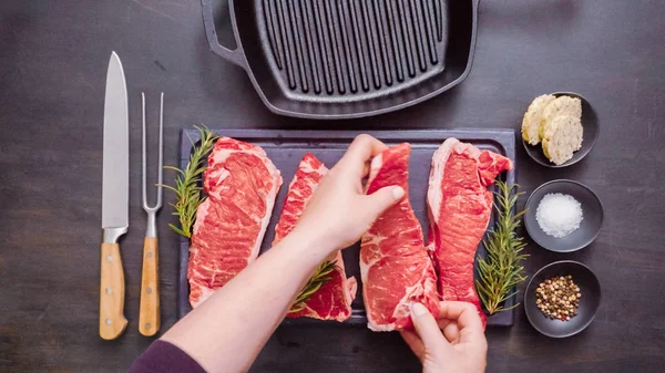 Dökme demir tavada ham New York şerit biftek.