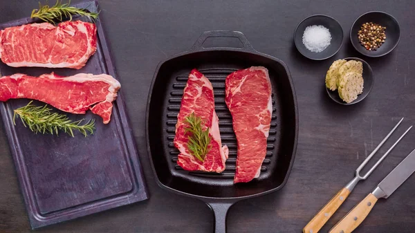 Dökme demir tavada ham New York şerit biftek.