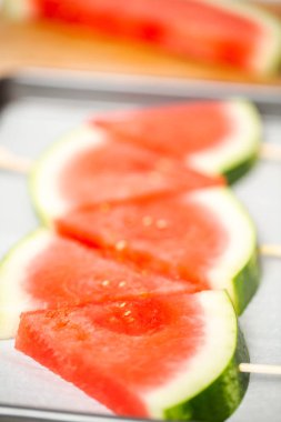 Ahşap sopa üzerinde üçgen şekillerde karpuz dilimli.