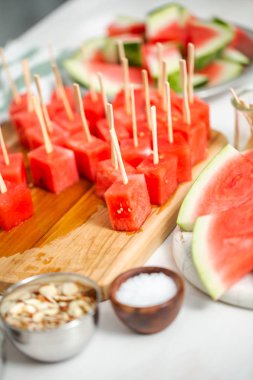 Çikolata ve sprinked deniz tuzu ve badem ile daldırma karpuz mezeler hazırlanıyor.