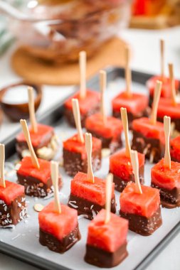 Çikolata ve sprinked deniz tuzu ve badem ile daldırma karpuz mezeler hazırlanıyor.