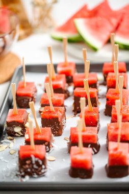 Çikolata ve sprinked deniz tuzu ve badem ile daldırma karpuz mezeler hazırlanıyor.
