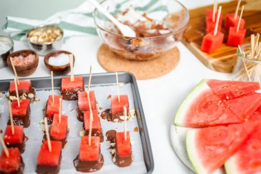 Çikolata ve sprinked deniz tuzu ve badem ile daldırma karpuz mezeler hazırlanıyor.