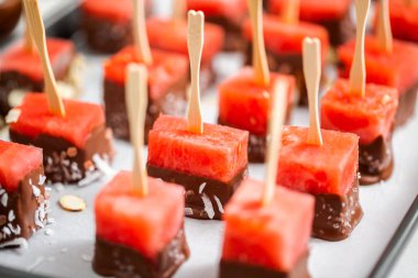 Çikolata ve sprinked deniz tuzu ve badem ile daldırma karpuz mezeler hazırlanıyor.