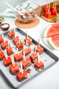 Çikolata ve sprinked deniz tuzu ve badem ile daldırma karpuz mezeler hazırlanıyor.