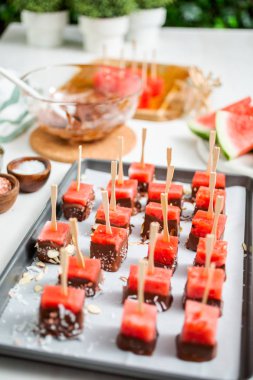 Çikolata ve sprinked deniz tuzu ve badem ile daldırma karpuz mezeler hazırlanıyor.