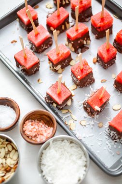Çikolata ve sprinked deniz tuzu ve badem ile daldırma karpuz mezeler hazırlanıyor.