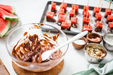 Çikolata ve sprinked deniz tuzu ve badem ile daldırma karpuz mezeler hazırlanıyor.