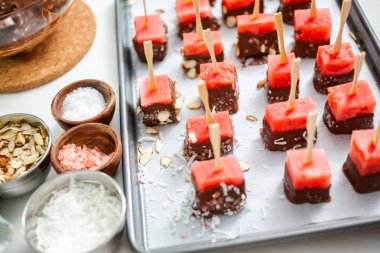 Çikolata ve sprinked deniz tuzu ve badem ile daldırma karpuz mezeler hazırlanıyor.