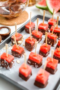 Çikolata ve sprinked deniz tuzu ve badem ile daldırma karpuz mezeler hazırlanıyor.
