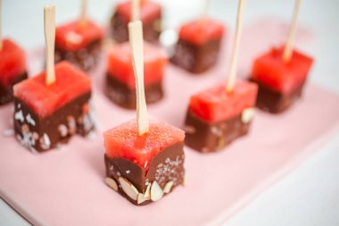 Çikolata ve sprinked deniz tuzu ve badem ile daldırma karpuz mezeler hazırlanıyor.