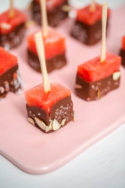 Çikolata ve sprinked deniz tuzu ve badem ile daldırma karpuz mezeler hazırlanıyor.
