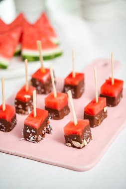 Çikolata ve sprinked deniz tuzu ve badem ile daldırma karpuz mezeler hazırlanıyor.