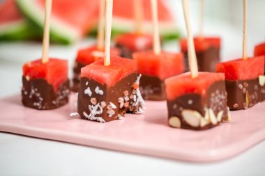 Çikolata ve sprinked deniz tuzu ve badem ile daldırma karpuz mezeler hazırlanıyor.