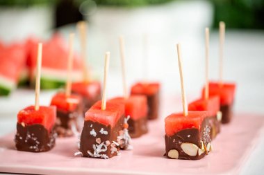 Çikolata ve sprinked deniz tuzu ve badem ile daldırma karpuz mezeler hazırlanıyor.