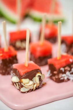 Çikolata ve sprinked deniz tuzu ve badem ile daldırma karpuz mezeler hazırlanıyor.