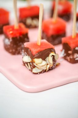 Çikolata ve sprinked deniz tuzu ve badem ile daldırma karpuz mezeler hazırlanıyor.