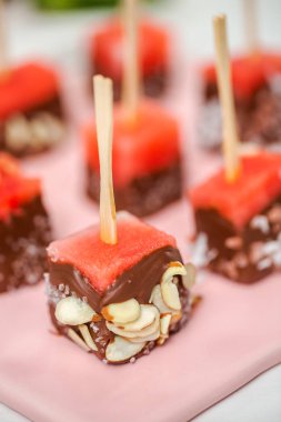 Çikolata ve sprinked deniz tuzu ve badem ile daldırma karpuz mezeler hazırlanıyor.