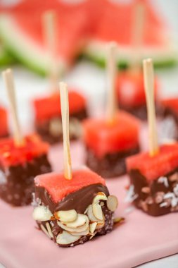Çikolata ve sprinked deniz tuzu ve badem ile daldırma karpuz mezeler hazırlanıyor.