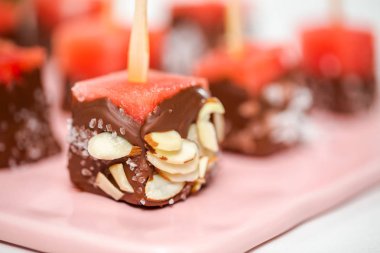 Çikolata ve sprinked deniz tuzu ve badem ile daldırma karpuz mezeler hazırlanıyor.