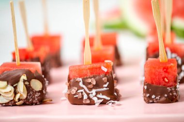 Çikolata ve sprinked deniz tuzu ve badem ile daldırma karpuz mezeler hazırlanıyor.