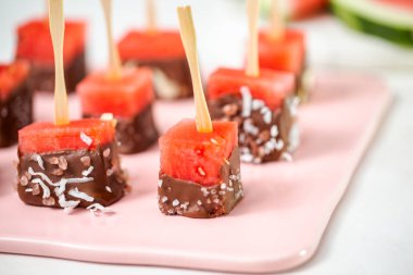 Çikolata ve sprinked deniz tuzu ve badem ile daldırma karpuz mezeler hazırlanıyor.