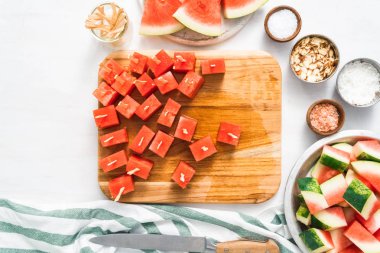 Çikolata ve sprinked deniz tuzu ve badem ile daldırma karpuz mezeler hazırlanıyor.