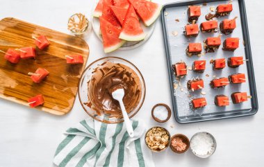 Çikolata ve sprinked deniz tuzu ve badem ile daldırma karpuz mezeler hazırlanıyor.
