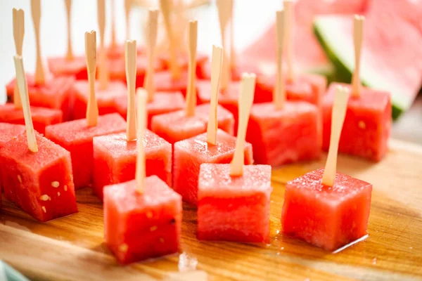 Çikolata ve sprinked deniz tuzu ve badem ile daldırma karpuz mezeler hazırlanıyor.