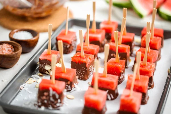 Çikolata ve sprinked deniz tuzu ve badem ile daldırma karpuz mezeler hazırlanıyor.