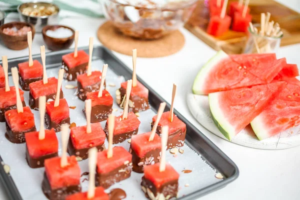 Çikolata ve sprinked deniz tuzu ve badem ile daldırma karpuz mezeler hazırlanıyor.
