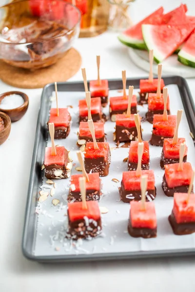 Çikolata ve sprinked deniz tuzu ve badem ile daldırma karpuz mezeler hazırlanıyor.